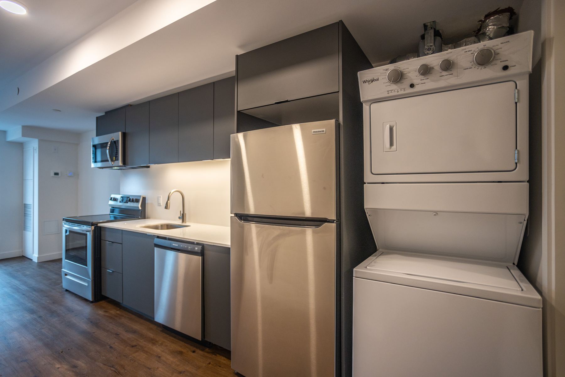 In-suite stacked washer and dryer beside the kitchen